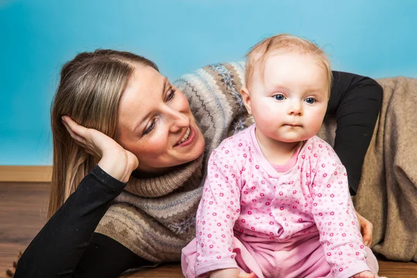 Baby babymeisje met moeder op houten vloer — Stockfoto