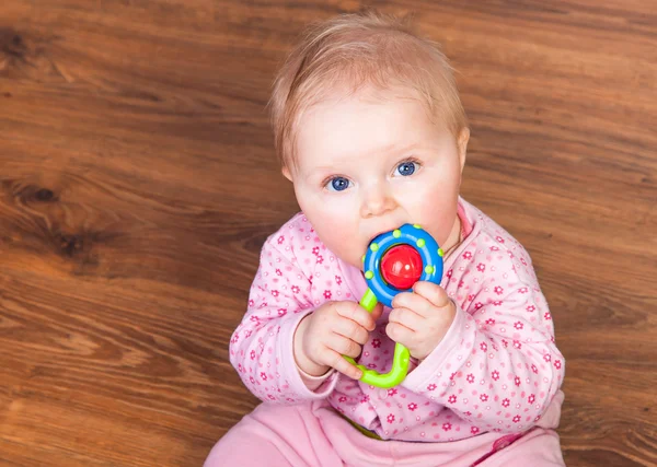Spädbarn flicka som leker i rummet på trägolv — Stockfoto