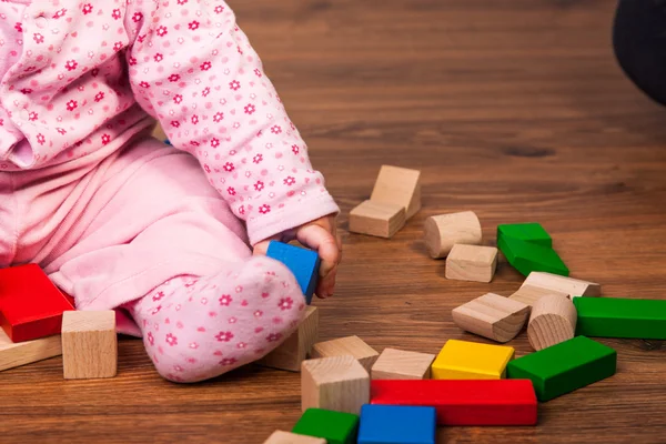 Infant girl playing in room on wooden floor — Stock Photo, Image