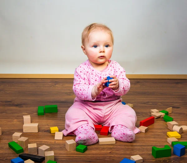 Niemowlę dziewczyna bawi sie w pokoju na podłodze drewnianej — Zdjęcie stockowe