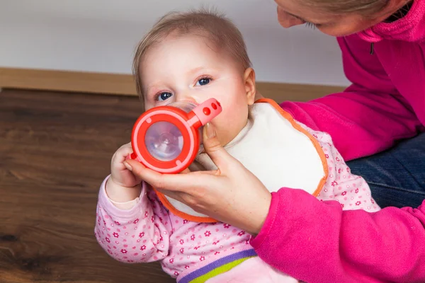 Madre che alimenta la bambina con una bottiglia di tè — Foto Stock