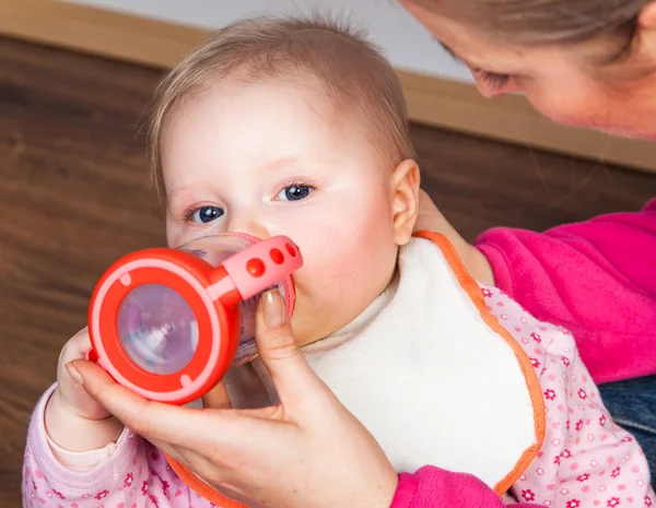 Mãe alimentando menina infantil com uma garrafa de chá — Fotografia de Stock