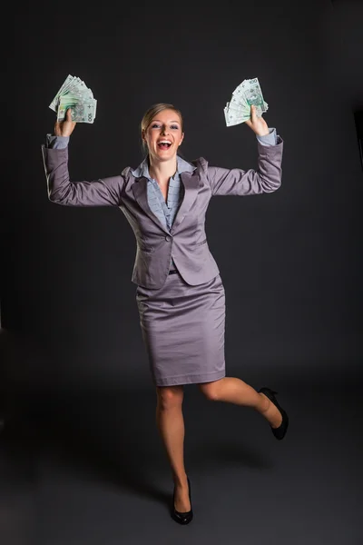 Mujer con pulido zloty dinero sobre fondo gris oscuro — Foto de Stock