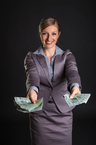 Женщина с польскими злотыми деньгами на темно-сером фоне — стоковое фото
