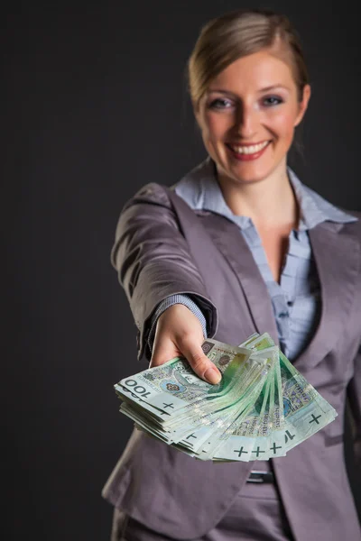 Mujer con pulido zloty dinero sobre fondo gris oscuro — Foto de Stock