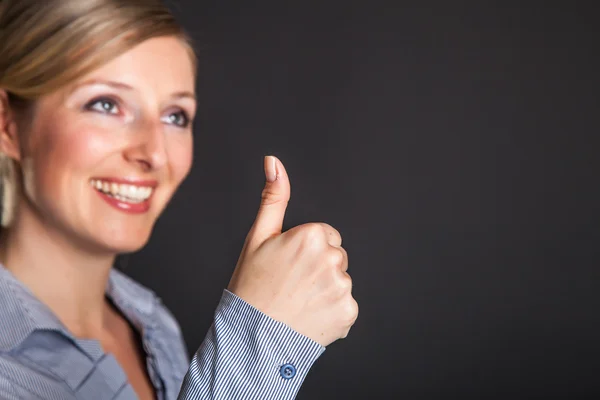 Businesswoman thumbs up on gray background — Stock Photo, Image