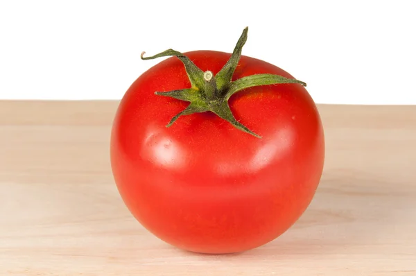 Tomate em tábua de madeira — Fotografia de Stock