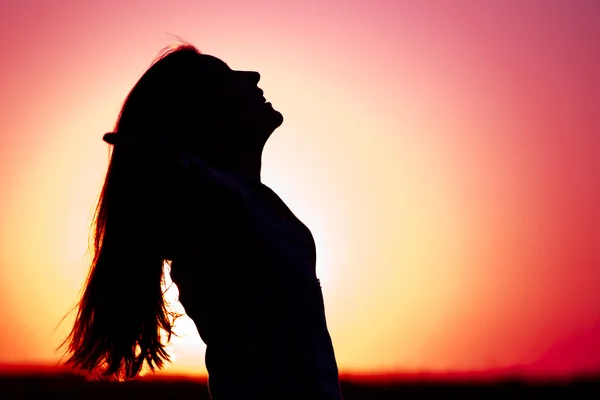 Žena uvolňující při západu slunce — Stock fotografie