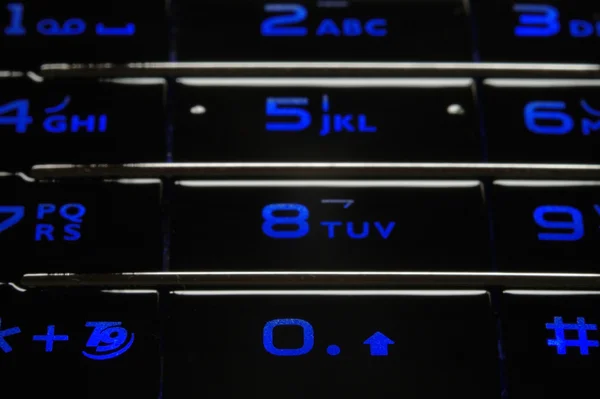 Синяя мобильная клавиатура в темноте — стоковое фото