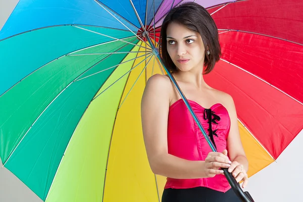 Женщина стоит под зонтиком — стоковое фото