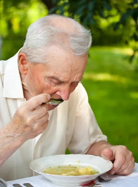 Старший мужчина ест — стоковое фото