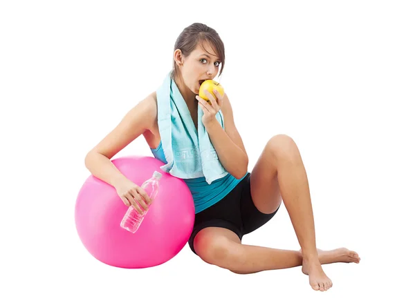 Молодая красивая женщина с яблоком и гимнастическим мячом — стоковое фото
