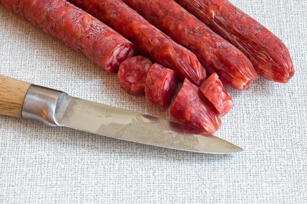 Salami with a sharp knife — Stock Photo, Image