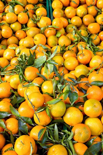 Clementine fresche con foglie verdi su un mercato — Foto Stock
