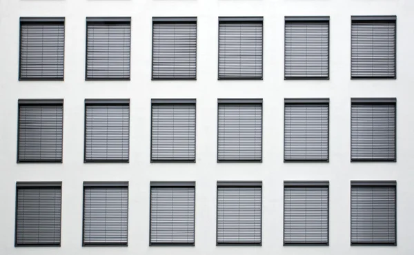 Fasad med grå fönsterluckor — Stockfoto