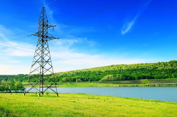 stock image High-voltage power line on the shore of the lake.