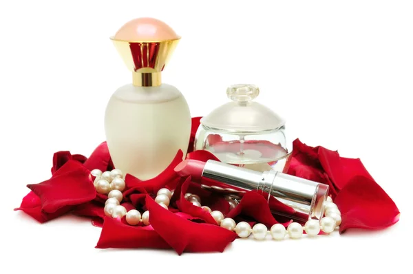 Perfume e colar de pérolas em pétalas de rosa — Fotografia de Stock