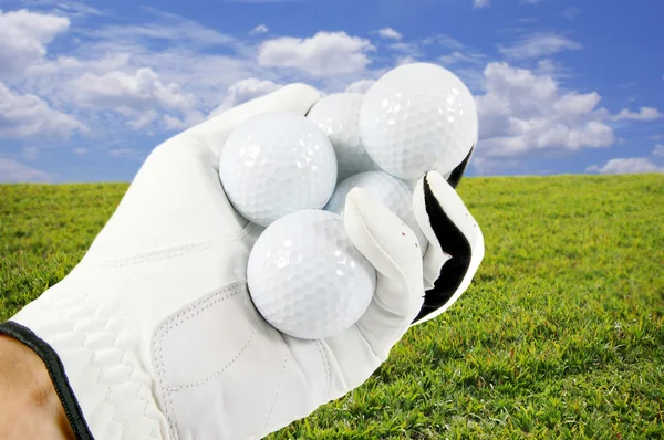 Golf topları ile el — Stok fotoğraf