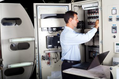 Technician repairing industrial machine with computer clipart