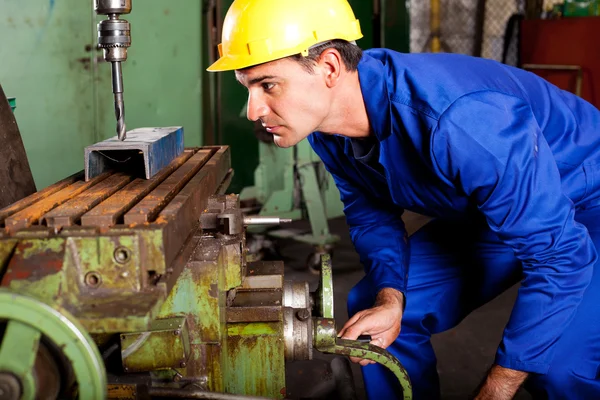 Maquinista operando prensa de perfuração industrial — Fotografia de Stock