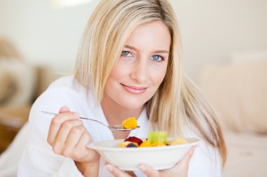 Young woman eating fruit salad clipart