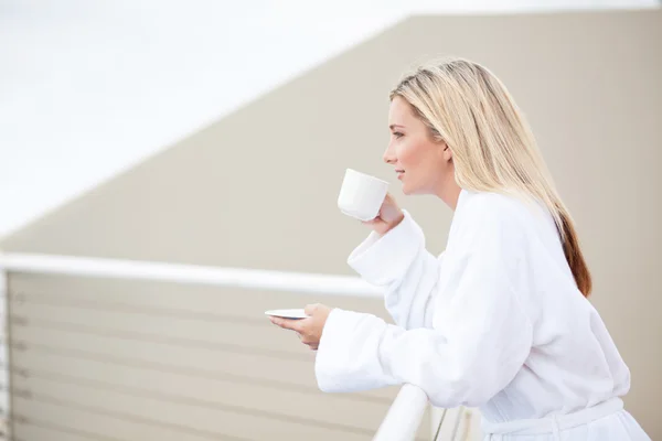 Молода жінка п'є каву вранці — стокове фото