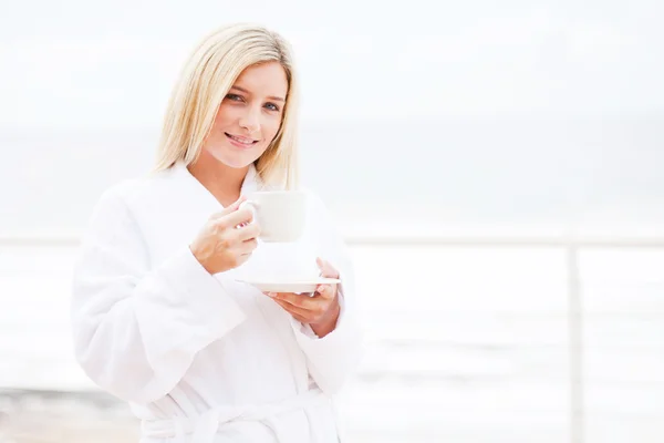 Гарненька молода жінка п'є чай вранці — стокове фото