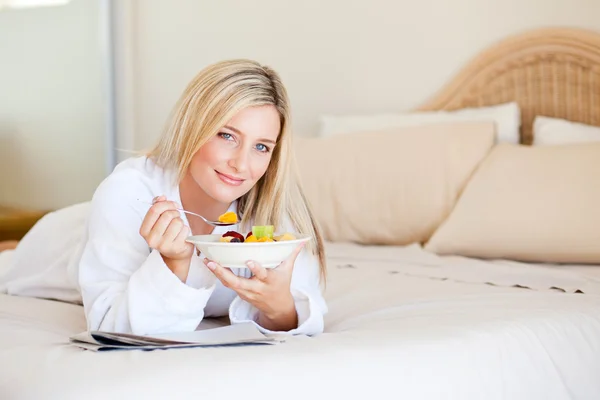 Healthy young woman eating fruit salad — Stock Photo, Image