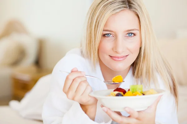 Young woman eating breakfast on bed — Stock Photo, Image