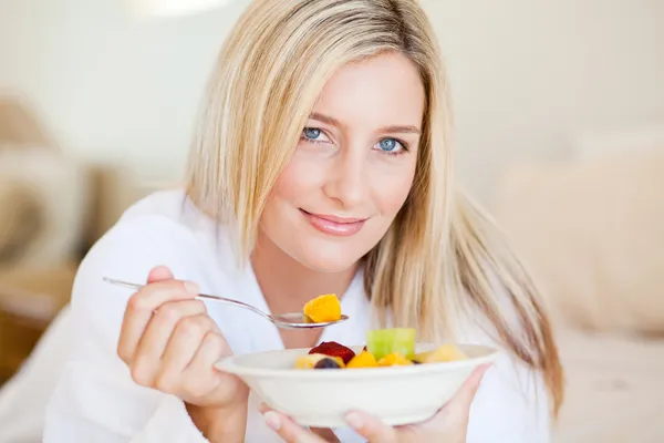 Mujer joven comiendo ensalada de frutas —  Fotos de Stock
