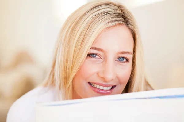 Happy young woman reading newspaper — Stock Photo, Image