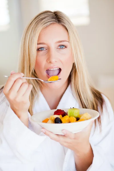 Mujer joven comiendo ensalada de frutas —  Fotos de Stock