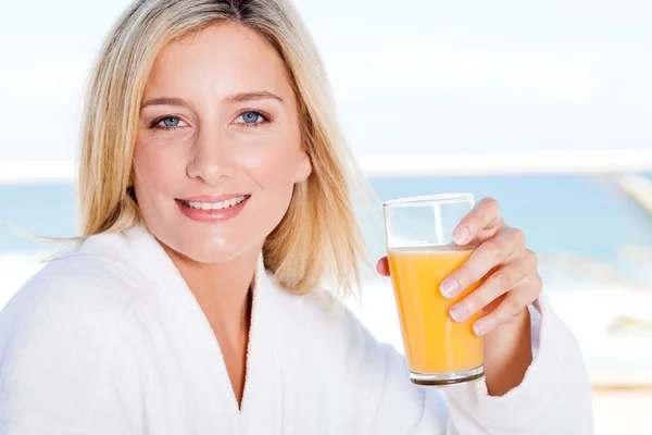 Junge Frau trinkt Orangensaft — Stockfoto