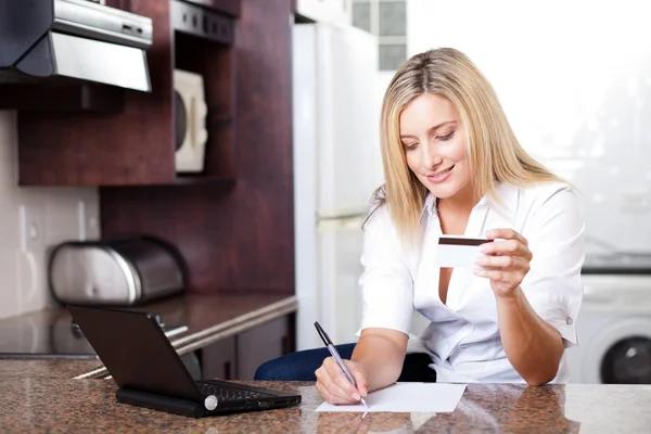 Mulher jovem calculando conta de cartão de crédito — Fotografia de Stock