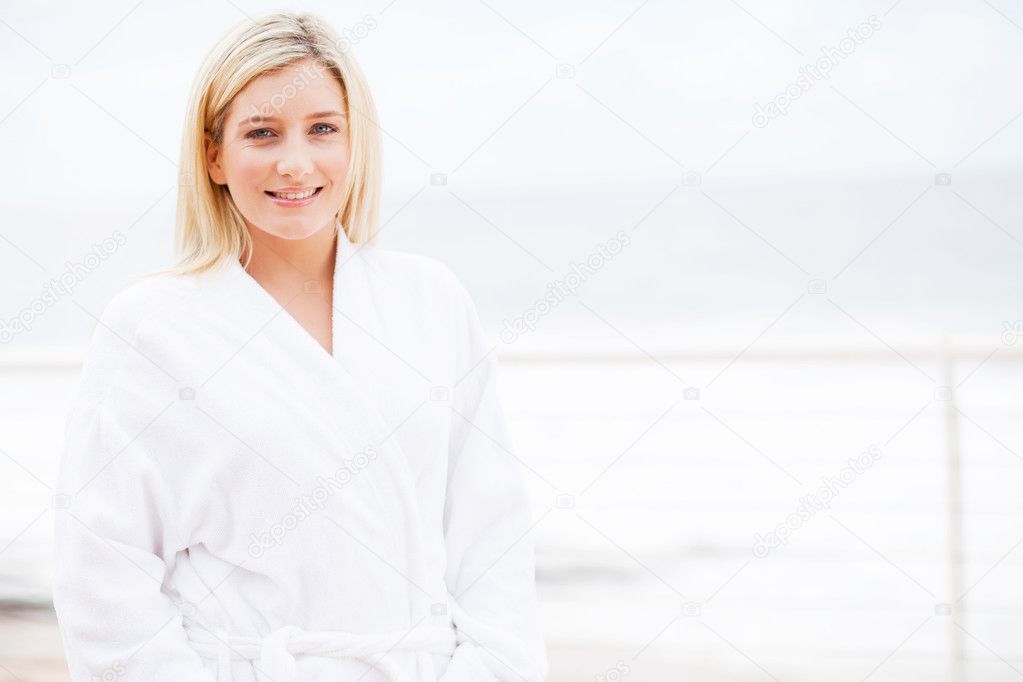 Young woman in bathrobe at home