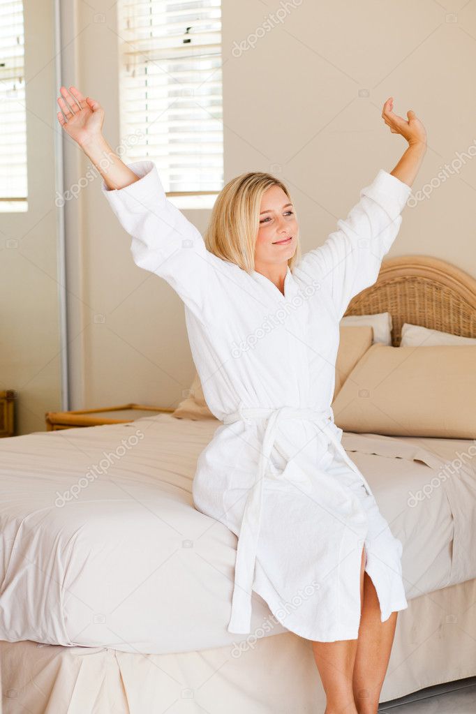 Young woman stretching on bed