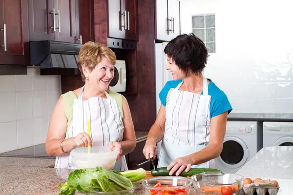 Senior mother and middle aged daughter cooking — Stock Photo, Image