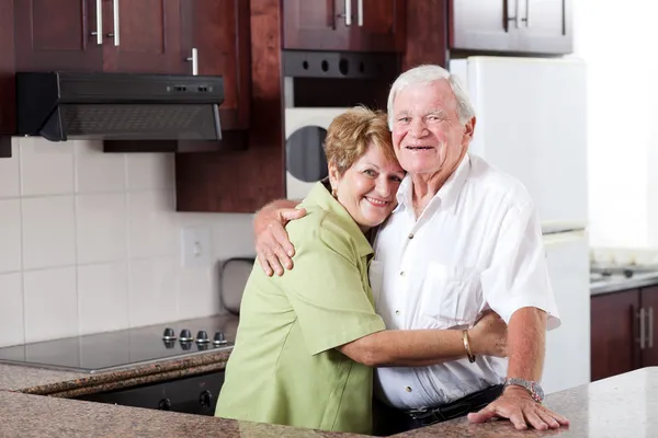 Пожилая пара обнимается дома — стоковое фото