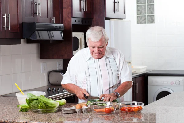 Elderly man cooking — Stock Photo, Image