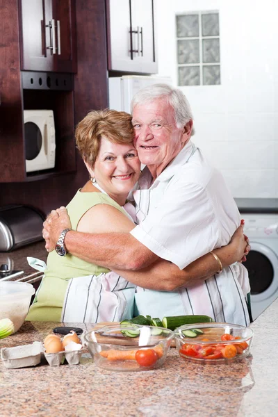 Seniorpaar umarmt sich in Küche — Stockfoto