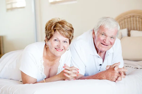 Senior couple lying on bed — Stock Photo, Image