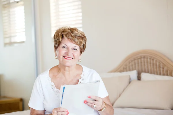 Happy senior kvinna läsa tidningen — Stockfoto