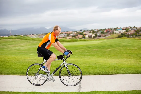 Senior man riding bicycle — Stock Photo, Image
