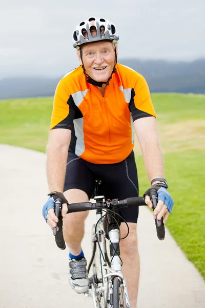 Щасливий старший чоловік їде на велосипеді — стокове фото