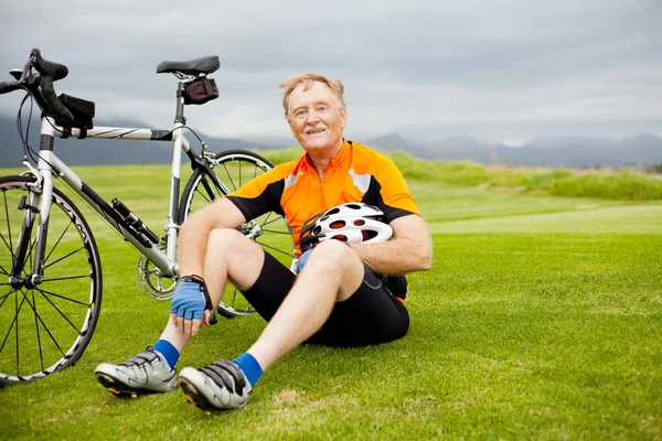 Старший велосипедист отдыхает — стоковое фото