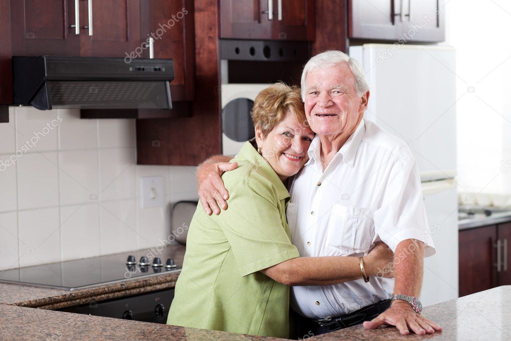 Elderly couple hugging at home