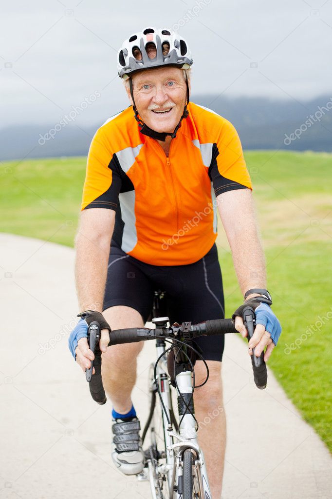 Happy senior man riding bicycle