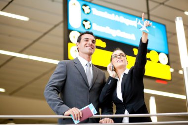 Business travellers checking boarding information clipart