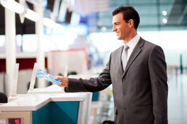 Businessman at airline check in counter clipart