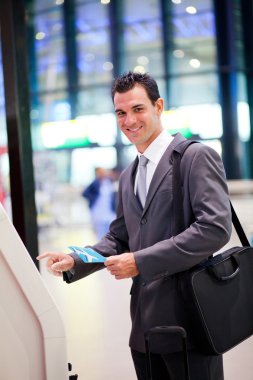 Businessman using self check in machine clipart
